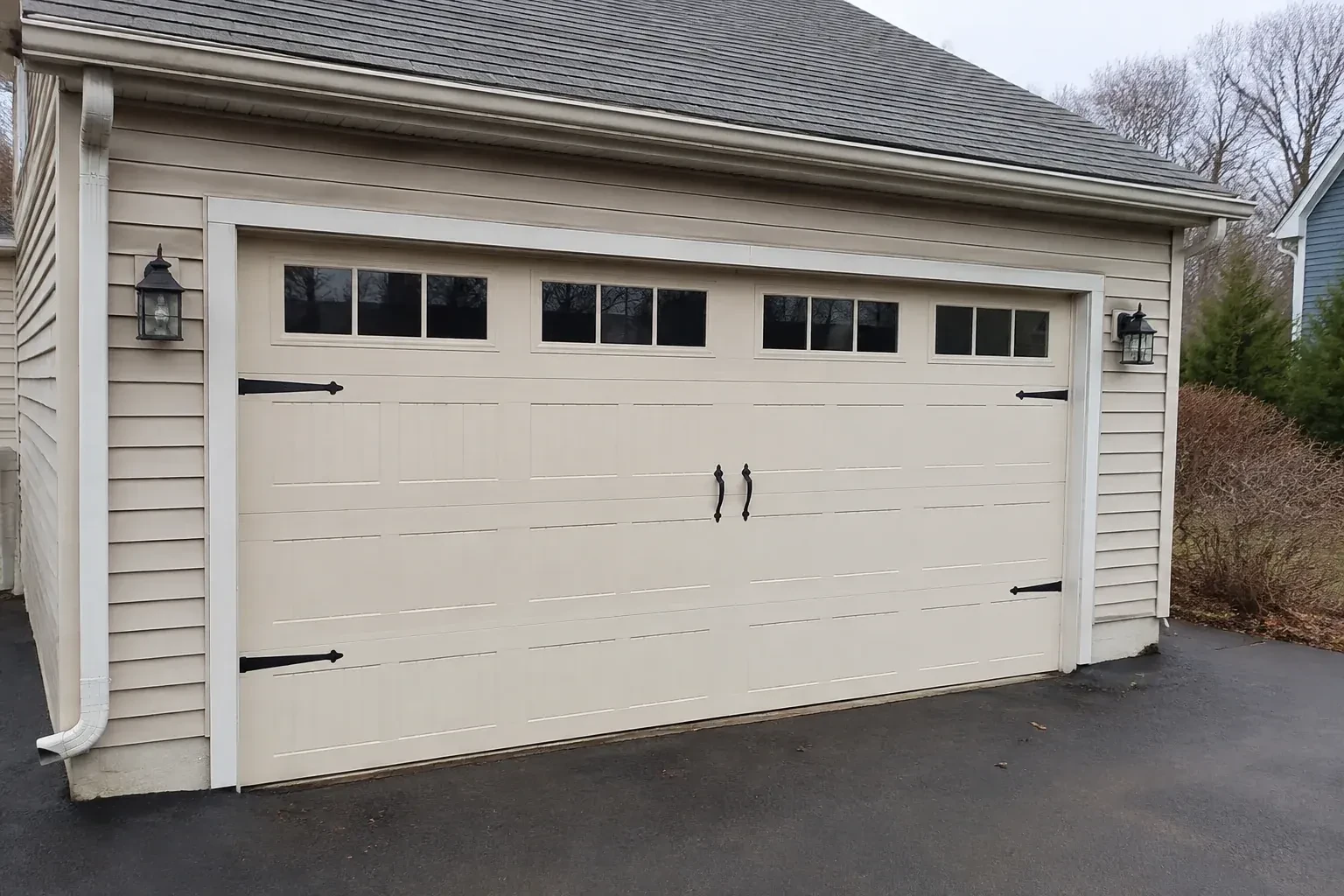 Cream carriage-house-style garage door with dark decorative hardware. — Carriage-House Garage Door Installation, Georgina