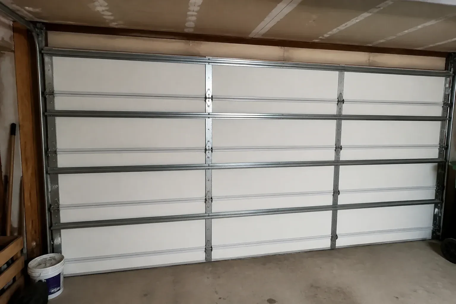 Interior of a closed sectional door with horizontal metal reinforcement struts. — Wind-Rated Garage Door Replacement, Georgina